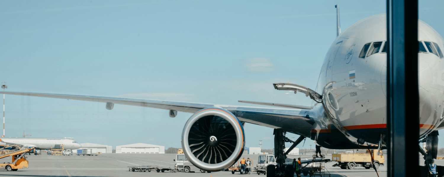 An airplane on the ground with blue skies and clouds in the background.